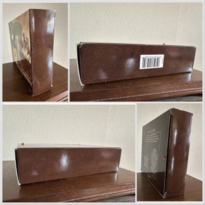 May include: A brown cardboard box with a white label on the side. The label has the text "STEPHEN" and a description of the product. The box is sitting on a wooden surface.