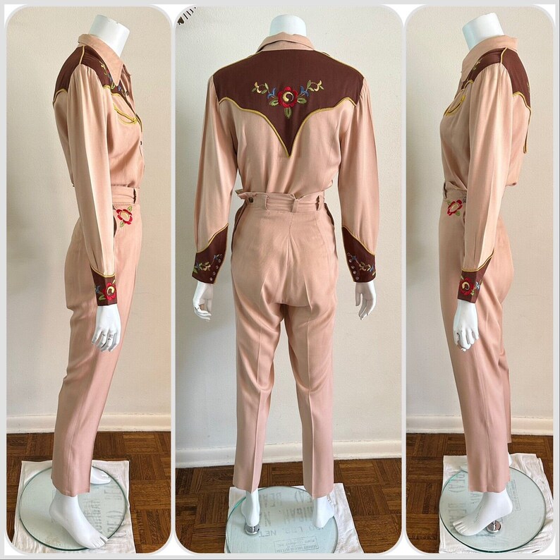 Pu&ograve; includere: Un completo in due pezzi di colore rosa chiaro con ricami marroni sul collo e sui polsini. La camicia ha un colletto a punta e maniche lunghe. I pantaloni hanno vita alta e gamba dritta.