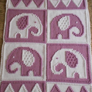 May include: A crocheted baby blanket with a pink and white color scheme. The blanket features four elephant designs in the center and a border of triangles.