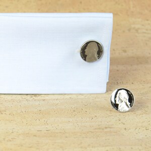May include: A pair of silver cufflinks featuring a profile of George Washington on each cufflink.