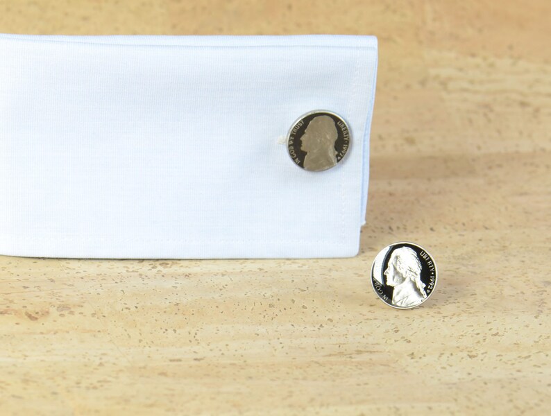 May include: A pair of silver cufflinks featuring a profile of George Washington on each cufflink.