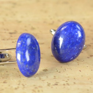 Peut inclure: Une paire de boutons de manchette avec des pierres ovales en lapis-lazuli serties dans de l'argent.