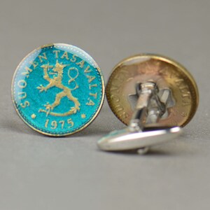 Pode incluir: Um par de bot&otilde;es de punho feitos com uma moeda finlandesa de 1975 que apresenta um le&atilde;o sobre um fundo turquesa. Os bot&otilde;es de punho s&atilde;o de prata com um acabamento dourado.
