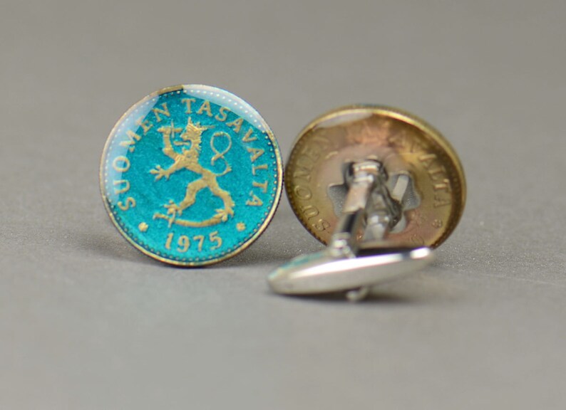 Pode incluir: Um par de bot&otilde;es de punho feitos com uma moeda finlandesa de 1975 que apresenta um le&atilde;o sobre um fundo turquesa. Os bot&otilde;es de punho s&atilde;o de prata com um acabamento dourado.