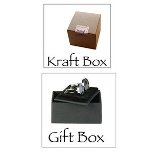 May include: Two cufflinks in a black gift box with a brown kraft box next to it. The kraft box has a label that says "Hand made".