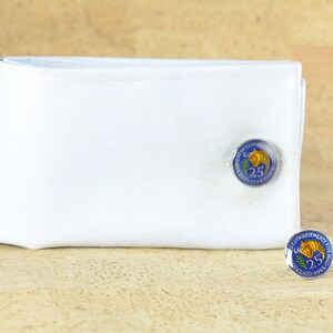 Peut inclure: Une paire de boutons de manchette avec un motif bleu et or avec le texte "Government of Cyprus Twenty-Five Years 1960-1985".