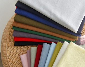Puede incluir: Un conjunto de muestras de tela en varios colores, incluyendo blanco, azul marino, verde oliva, marrón, verde, gris, rojo y negro. Las muestras están dispuestas en forma de abanico, con los colores más claros en la parte superior y los colores más oscuros en la parte inferior.