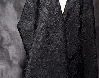 Könnte beinhalten: Schwarzer Stoff mit Paisley-Muster. Der Stoff ist strukturiert und hat einen leichten Glanz.