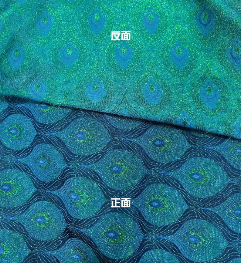 以下が含まれることがあります： 孔雀の羽根模様の生地のクローズアップ。生地は青と緑で、キラキラした仕上げになっています。画像の上半分には「反面」という文字が書かれており、下半分には「正面」という文字が書かれています。