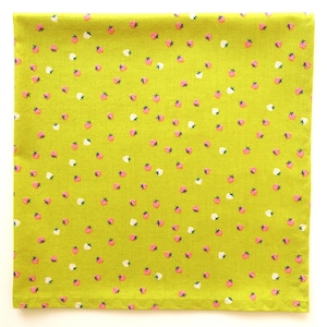 May include: A square, lime green fabric with a repeating pattern of pink and white strawberries. The strawberries have green stems and are scattered across the fabric. The fabric is likely cotton or a similar material.