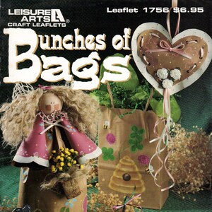 May include: A craft leaflet titled "Bunches of Bags" with a brown paper bag with a beehive design, a brown paper bag with a heart design, a brown paper bag with a flower design, and a brown paper bag with a doll design. The leaflet is from Leisure Arts.