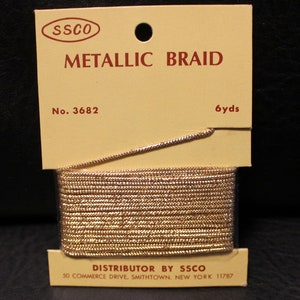 May include: A gold metallic braid on a white card with the text "SSCO Metallic Braid No. 3682 6yds Distributor by SSCO 50 Commerce Drive, Smithtown, New York 11787"
