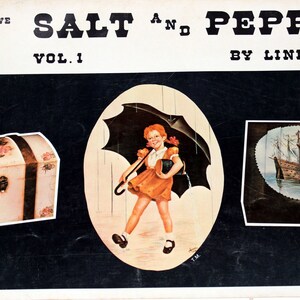 May include: A vintage book cover featuring the title "Salt 'n' Pepper Vol. 1" by Linda Wise. The cover features three images: a painted wooden chest, a girl with a red umbrella walking in the rain, and a painted wooden ship.