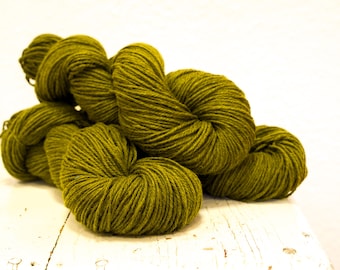May include: A pile of soft, green yarn skeins. The yarn is a deep, rich green color and is perfect for knitting or crocheting.