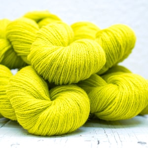 Pode incluir: Um monte de novelos de l&atilde; amarelo brilhante, perfeitos para tricotar ou fazer croch&ecirc;.