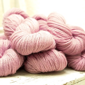 May include: A pile of soft, pink yarn skeins, perfect for knitting or crocheting projects.