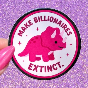 May include: A circular sticker featuring a bright pink triceratops dinosaur in the center. The text "MAKE BILLIONAIRES EXTINCT." is printed in bold pink letters along the top and bottom edges. Small pink stars are scattered around the dinosaur.