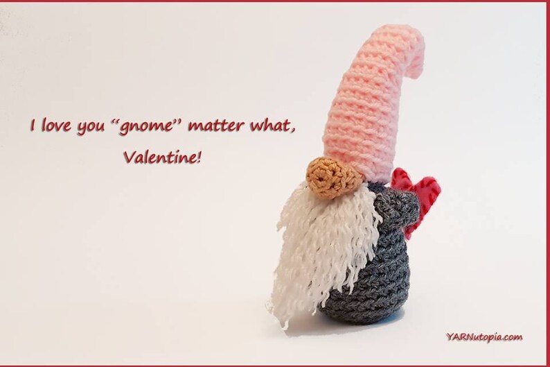 May include: A crocheted gnome holding a red heart. The gnome has a pink hat, a white beard, and a gray body. The text "I love you "gnome" matter what, Valentine!" is written in red on a white background.
