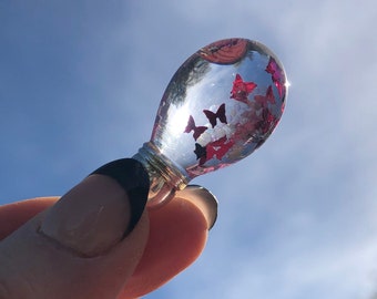 Perle en verre remplie d'huile transparente, petites perles et papillons