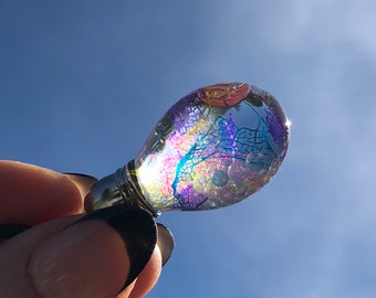 Glass bead filled with transparent oil with pearls and colorful veil leaves