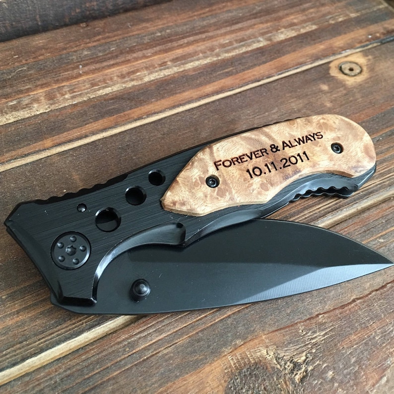 May include: A black pocket knife with a wood handle engraved with "FOREVER & ALWAYS 10.11.2011".