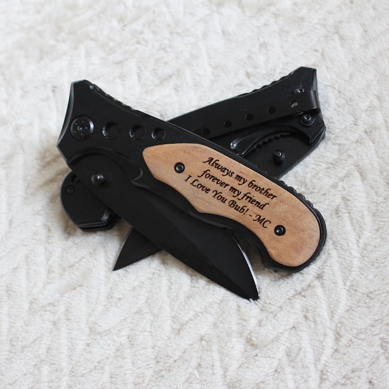 May include: A black pocket knife with a wooden handle engraved with the message "Always my brother forever my friend I Love You Bub! - MC".