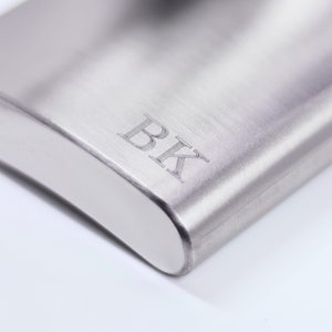 May include: A silver flask with the initials "BK" engraved on the front.