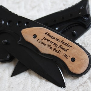 May include: Black pocket knife with a wooden handle engraved with the message "Always my brother forever my friend I Love You Bub! -MC"