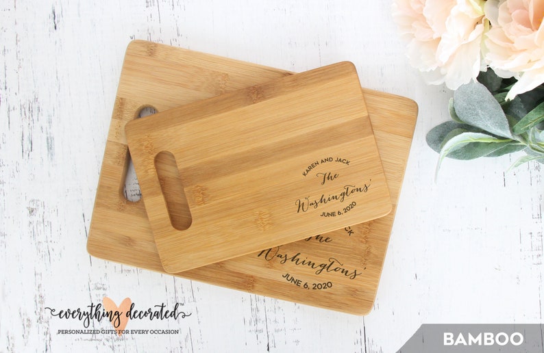 May include: Two wooden cutting boards with a handle. The smaller board is on top of the larger board. Both boards are engraved with the text "Karen and Jack The Washingtons June 6, 2020".