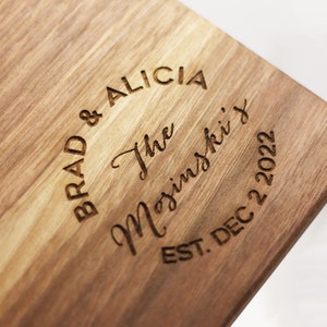 May include: A wooden cutting board with the text "Brad & Alicia The Majinski's Est. Dec 22 2022" engraved in a circle.