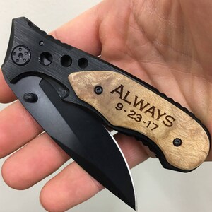May include: A black pocket knife with a wood handle engraved with the words "ALWAYS 9-23-17".