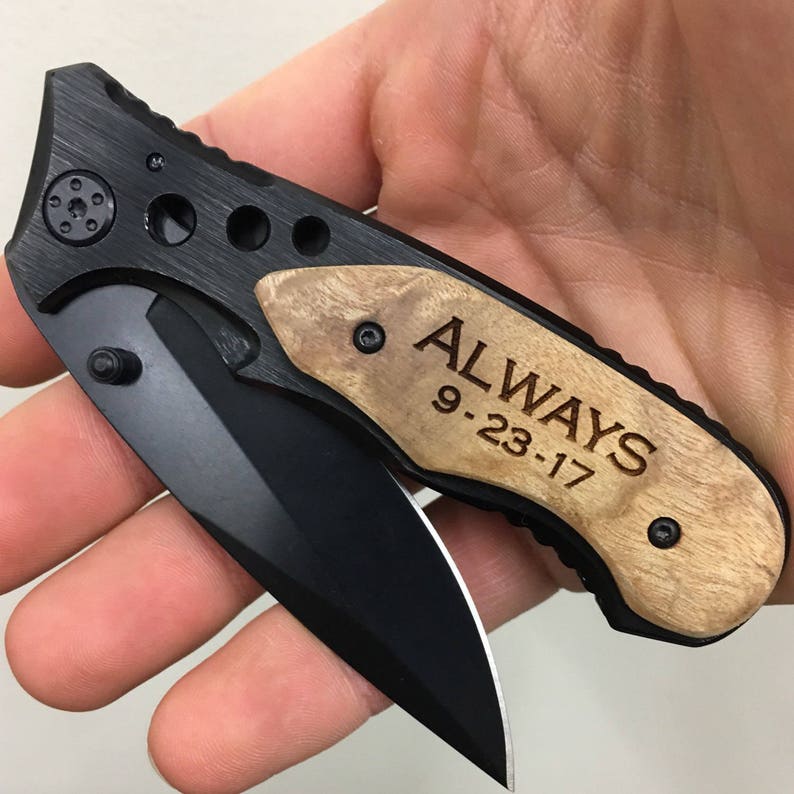 May include: A black pocket knife with a wood handle engraved with the words "ALWAYS 9-23-17".