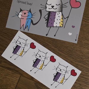 Könnte beinhalten: Ein Bogen mit Aufklebern und eine Karte mit Cartoon-Katzen. Die Katzen halten herzförmige Ballons und sind mit bunten Mustern verziert. Der Text "Spread love!" ist ebenfalls auf der Karte zu sehen.