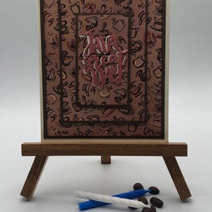 May include: A white ceramic mug with a black handle and the text "But First, Coffee" in a black, handwritten-style font. The mug is on a white surface.