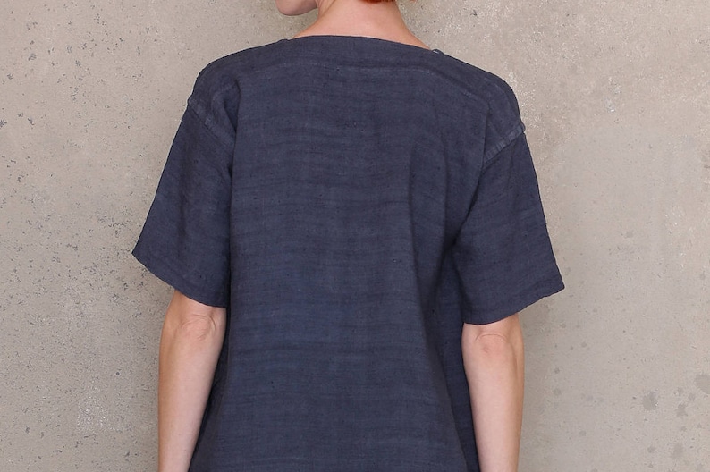 May include: A dark blue, short-sleeved t-shirt with a scoop neck.