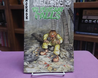 May include: A comic book titled Welcome to Pleasant Falls, Chapter Two, featuring a horror theme. The cover art depicts a clown in yellow clothing sitting on a log in a forest, surrounded by scattered trash and debris on the ground.