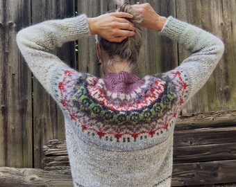 Pull Fair Isle islandais tricoté à la main en laine naturelle mélangée, coloris blanc cassé et gris clair, avec un motif islandais coloré.