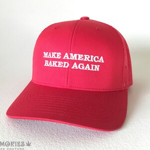 May include: Red trucker hat with a white embroidered slogan "Make America Baked Again".