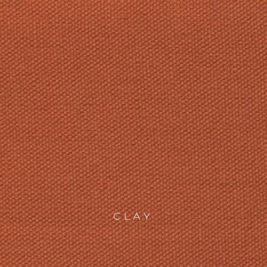 Clay organic cotton canvas is a sun baked orange color and has a coarse texture. The fabric is made from organic cotton fibers that are woven together in a plain weave. The fabric is durable, breathable and eco-friendly.