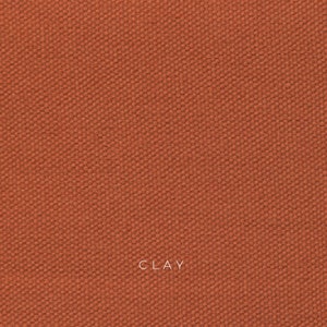 Clay organic cotton canvas is a sun baked orange color and has a coarse texture. The fabric is made from organic cotton fibers that are woven together in a plain weave. The fabric is durable, breathable and eco-friendly.