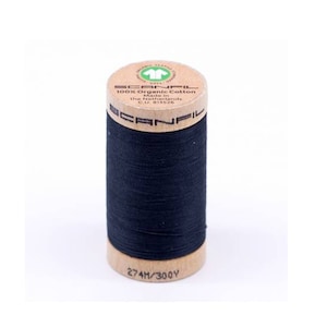 May include: A spool of black 100% organic cotton thread from Scanfil, made in the Netherlands. The spool is made of wood and has the brand name and details printed on it. The spool is 274 meters/300 yards long.