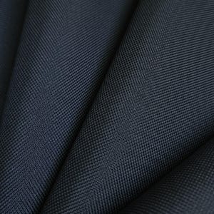 May include: A dark navy blue fabric featuring a tight, uniform basketweave texture. The material is folded into deep, soft pleats, creating a series of shadows and highlights that emphasize the consistent, dense grid pattern of the weave.