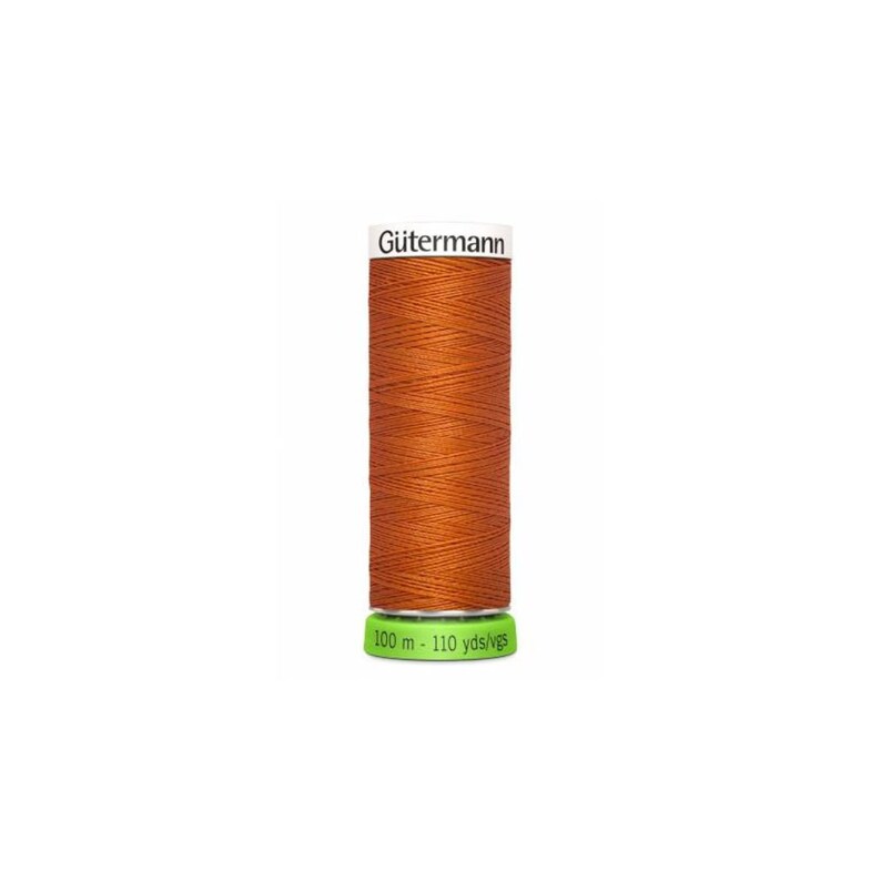 A spool of orange thread with a white label that reads 'Gütermann' and a green label that reads '100 m - 110 yds/vgs'. Made of recycled fibers.