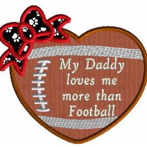 May include: A brown heart-shaped football with a white bow and paw print design. The text "My Daddy loves me more than Football" is written in white on the football.
