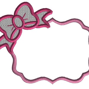 Può includere: Una cornice ricamata rosa e bianca con un fiocco rosa nell'angolo in alto a sinistra. La cornice è vuota e pronta per essere personalizzata.