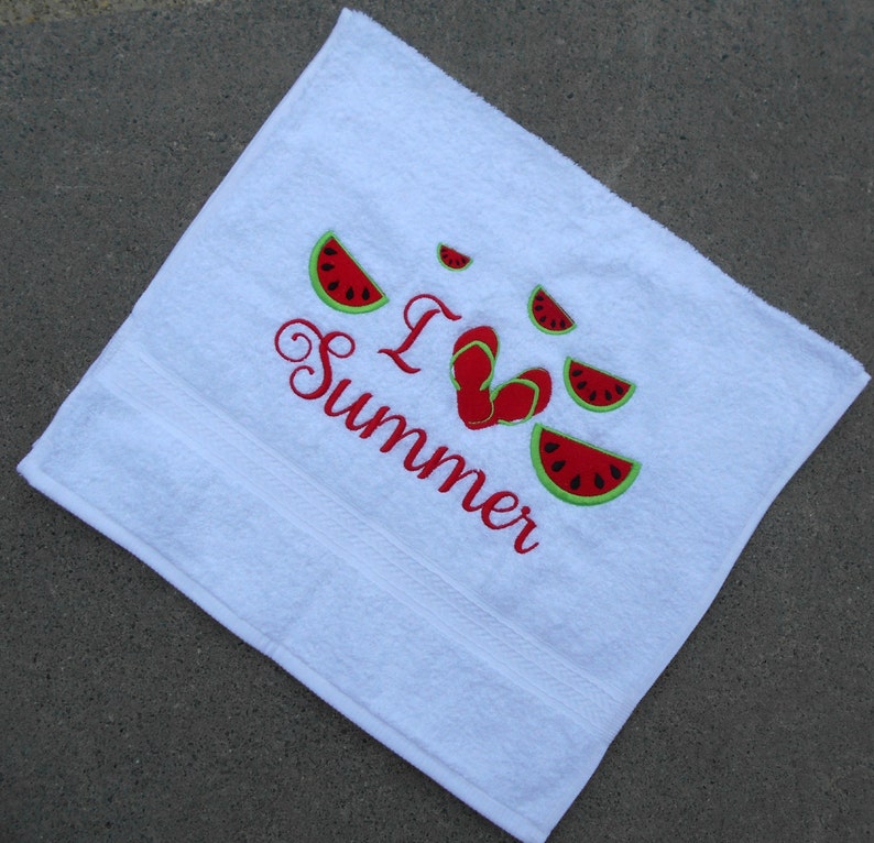 May include: White beach towel with red embroidery that says "I Love Summer" with a heart shape made of red flip flops and watermelon slices around the text.