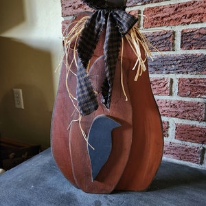 Standing primitive wooden pumpkin with crow