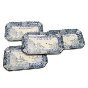 May include: Three rectangular ceramic trays featuring a blue and white landscape illustration. The center of each tray depicts a coastal scene with sailboats and mountains, while the wide borders are decorated with geometric patterns.