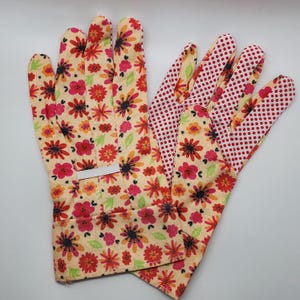 May include: A pair of gardening gloves with a floral print on the back and a red polka dot pattern on the palm side. The gloves are made of a soft, breathable fabric and are designed for comfort and durability.