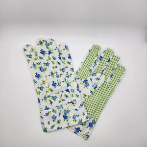 May include: A pair of gardening gloves with a floral print. One glove is white with blue flowers and green leaves, the other is green with white polka dots.